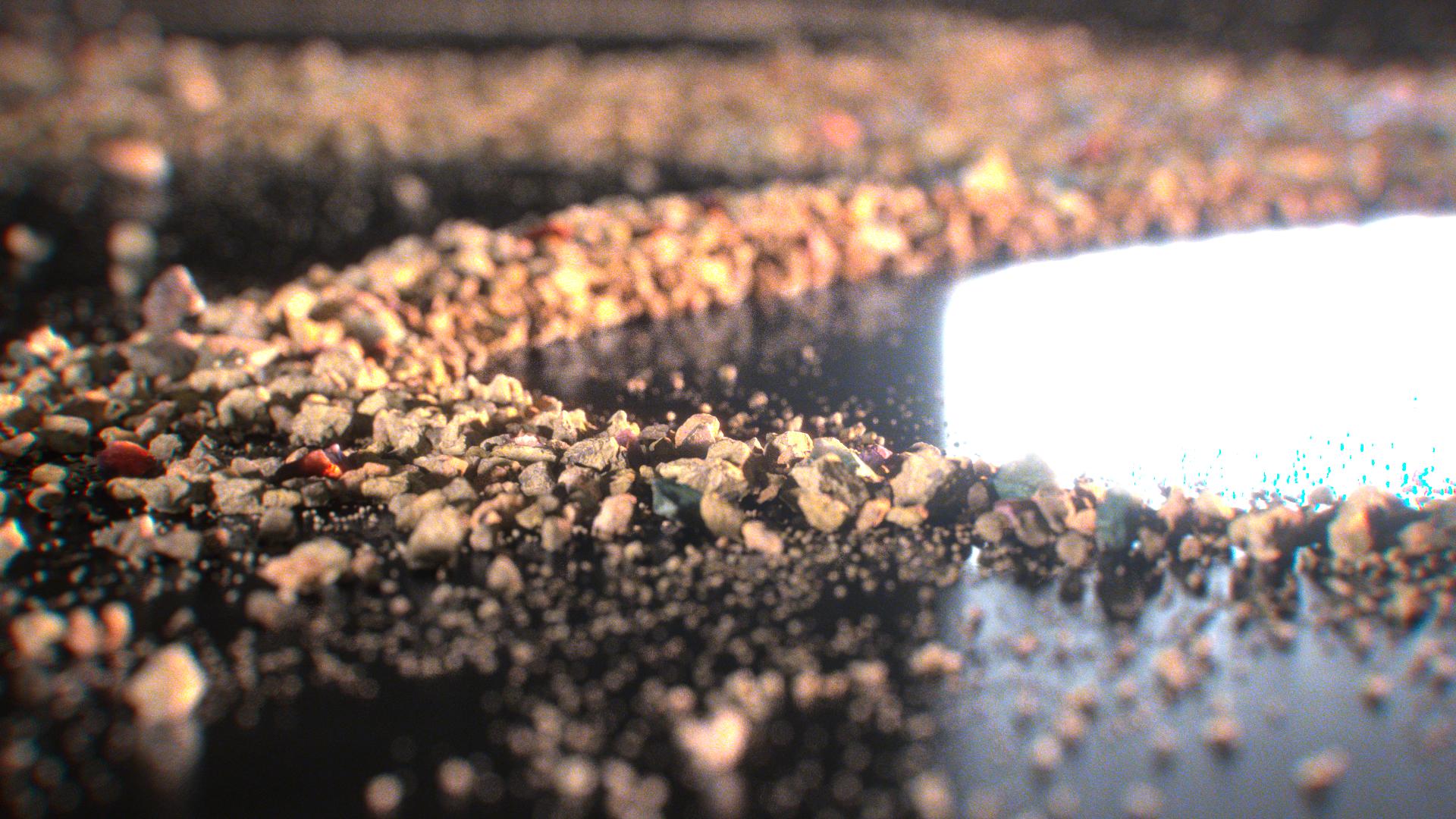 Extreme close-up of coarse grains defining the edge of a bright Chladni ridge beside a reflective dark surface